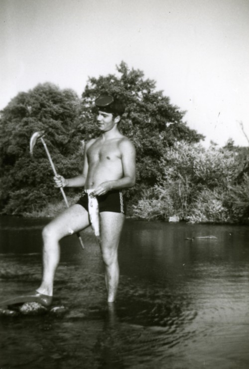 Ragazzo in costume al fiume mentre pesca