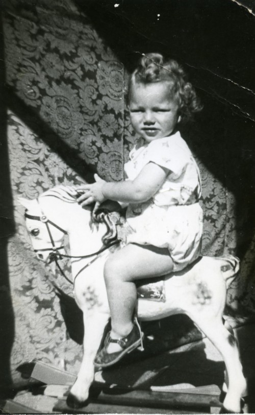 Bambina su cavallo a dondolo