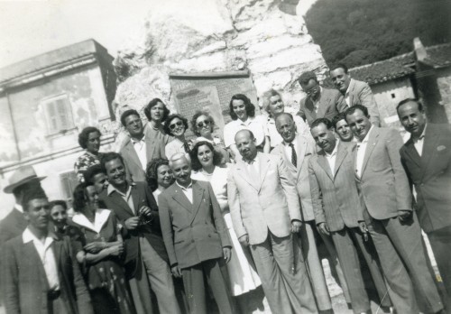 Angelo Rocchi con delle persone in posa sotto al Monumento ai caduti di Allumiere