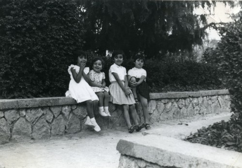 Quattro bambine sedute sul muretto del giardino comunale di Tolfa