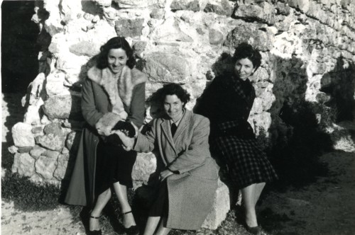 Diva Compagnucci e due donne posano sedute su delle rocce alla Rocca dei Frangipane