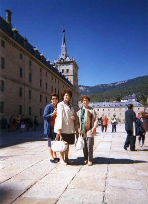 Diva Compagnucci con due donne in una piazza con il Monastero di El Escorial sullo sfondo