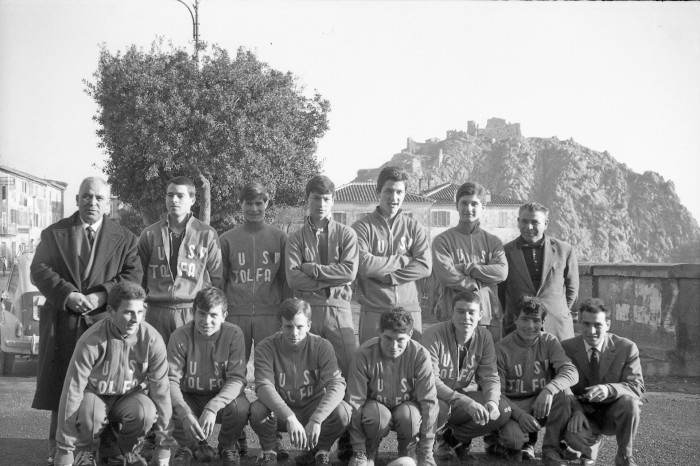 Squadra con la divisa dell'Unione Sportiva Tolfa in piazza Vittorio Veneto con alle spalle la Rocca dei Frangipane