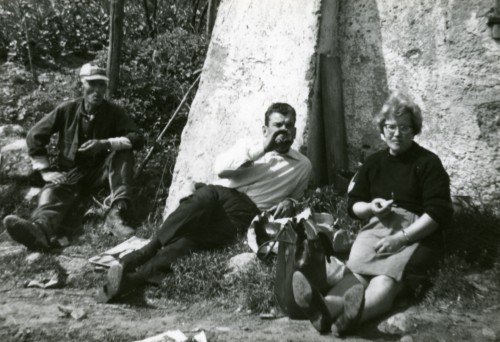 Tre persone mangiano sedute a terra