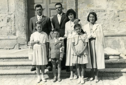 Due uomini, due donne, due bambine e un bambino fuori dalla chiesa di Sant'Egidio