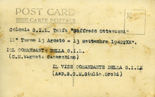 Retro di una cartolina con iscrizione a macchina “Colonia GIL Tolfa “Goffredo Ottaviani”/ II° Turno 13 agosto = 13 settembre 1942 XX°./ IL COMANDANTE DELLA G. I . L./ (C. M. Vignati Gioacchino)/ IL VICE COMANDANTE DELLA G. I. L./ (Asp. S. C. M. Giulio Orchi)